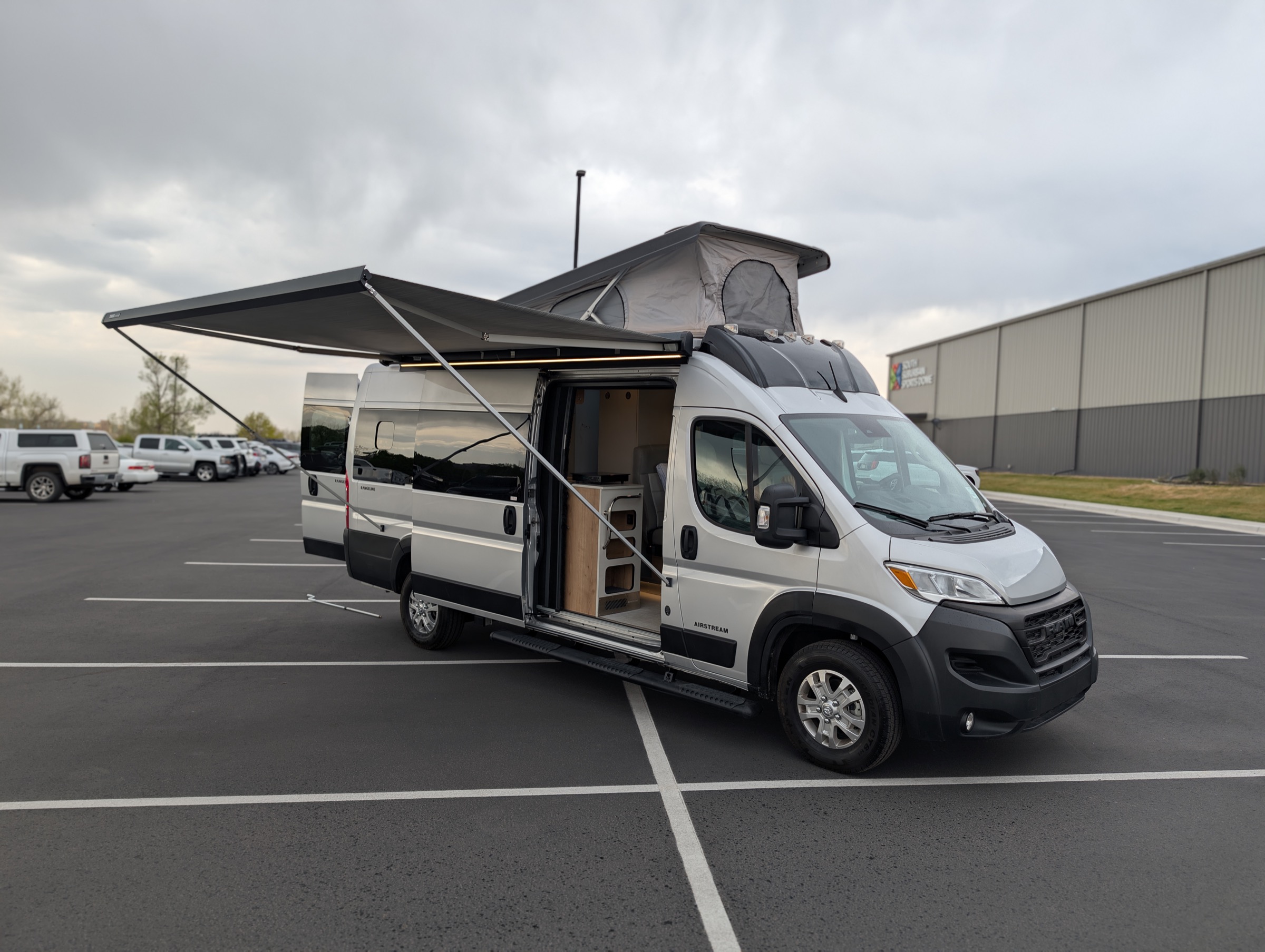 Airstream Rangeline set up for camping with side awning extended and pop-top roof deployed — Colorado RV rental from rent-rv.co.
